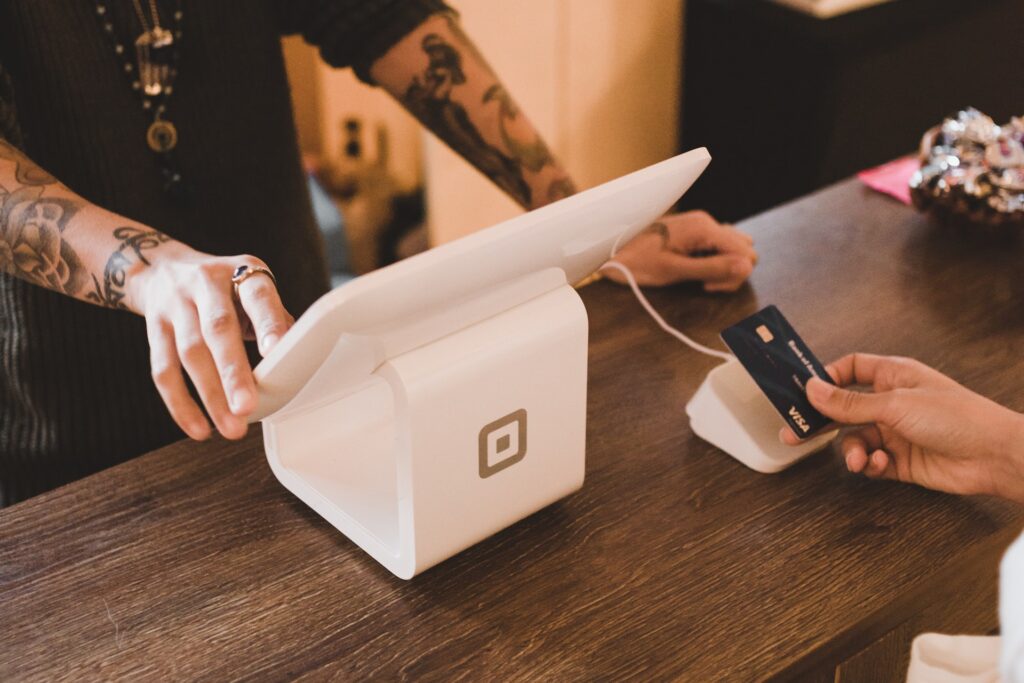 Patron making a contactless payment using credit card.