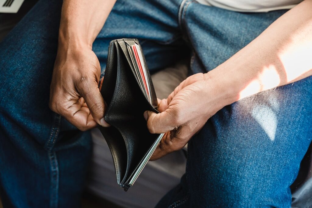 Man looking in his empty wallet.